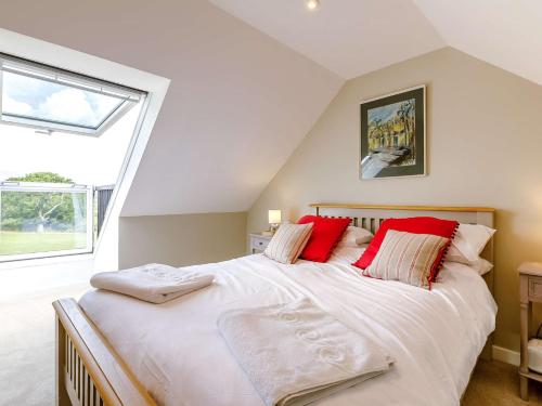 a bedroom with a large white bed with red pillows at 2 Bed in Sturminster Newton 88265 in Fiddleford