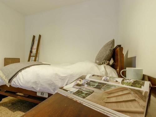 a bedroom with a bed with a magazine on a table at 2 Bed in St Andrews 78228 in Ceres