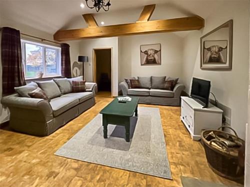 a living room with a couch and a table at Byre Cottage in Billingshurst