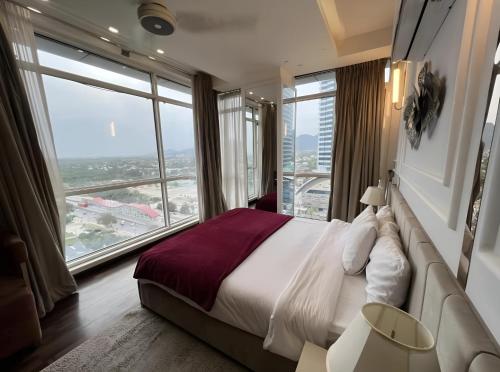 a bedroom with a large bed and a large window at Skyline Premium Luxury Apartments Elysium Facing Centaurus Mall Islamabad - LMY in Islamabad