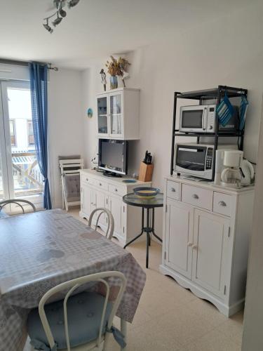a kitchen with a table and a microwave at Algues 2 in Quend-Plage
