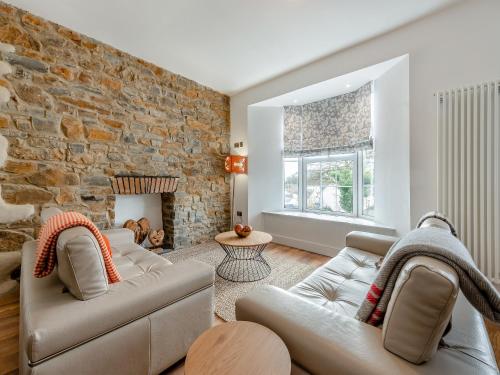 a living room with two couches and a stone wall at Sandy View - Uk43056 in Saundersfoot