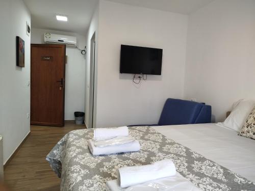 a hotel room with a bed and a tv on the wall at Serenita Stone House in Becici