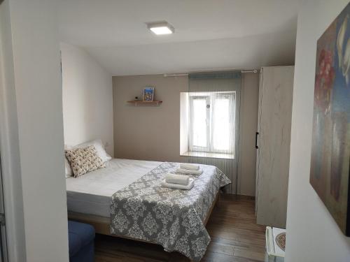 a small bedroom with a bed and a window at Serenita Stone House in Becici