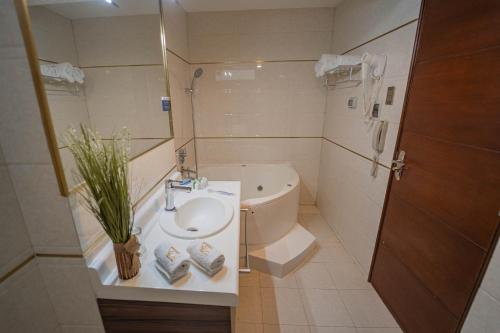 a bathroom with a sink and a toilet and a tub at Gran Recreo Hotel - Trujillo - Perú in Trujillo
