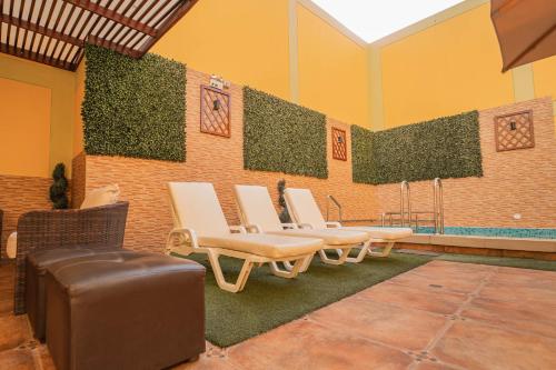 a group of chairs and a wall with plants at Gran Recreo Hotel - Trujillo - Perú in Trujillo
