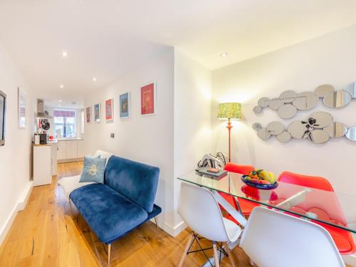 a living room with a blue chair and a desk at Town Square Apartment - Uk45611 in Alnwick