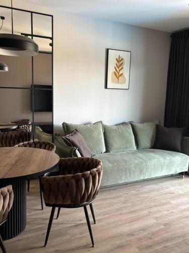 a living room with a green couch and a table at Czarna Perła Hel in Hel