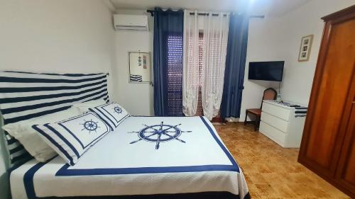 a bedroom with a large bed with a nautical themed bedspread at Gente di Mare Apartment Tropea Center in Tropea