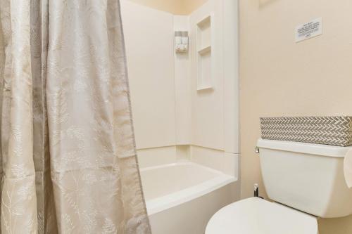 a bathroom with a toilet and a shower curtain at Sunny Large Two Bedroom Townhouse - Pool in Pensacola