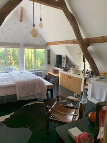 Cet appartement comprend une chambre avec un lit et une cuisine avec des fenêtres. dans l'établissement Maison architecte pays d Auge, à Préaux