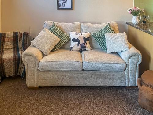 a couch with pillows with a cow on it at Beckside Court in Brampton