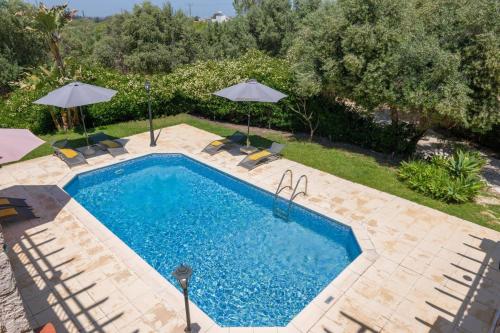 an image of a swimming pool with umbrellas at Villa Lena by Villa Plus in Prodhromi