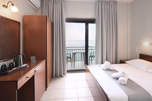 a hotel room with a bed and a balcony at Anesis in Platamonas