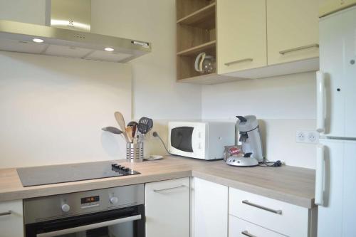 La cuisine est équipée de placards blancs et d'un four micro-ondes blanc. dans l'établissement Appart 2 pièces 4 couchages BANYULS SUR MER BN400-031, à Banyuls-sur-Mer