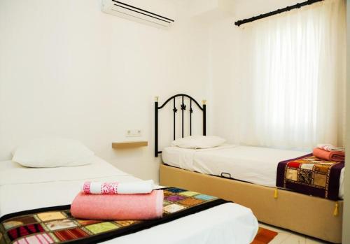 Un dormitorio con dos camas y una ventana. en Villa Dalyan Emirhan, en Ortaca