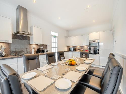 a kitchen with a dining room table and chairs at Kerrytonlia Cottage in Mountstuart