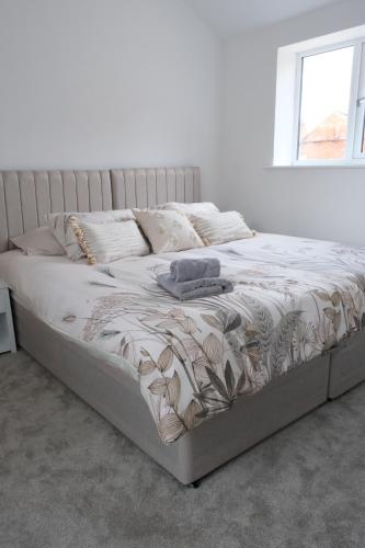 a large bed in a white room with a bedskirtspectspectspects at The Calf House in Sibbertoft