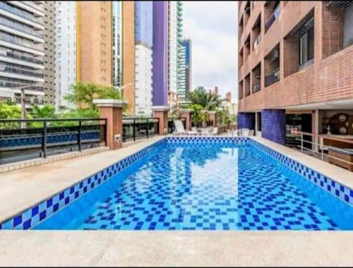 a swimming pool in the middle of a building at Flat Acolhedor e Familiar in Fortaleza