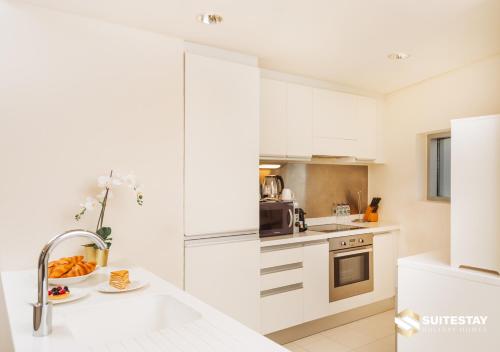 a kitchen with white cabinets and a sink at Fashion Avenue - Dubai Mall in Dubai