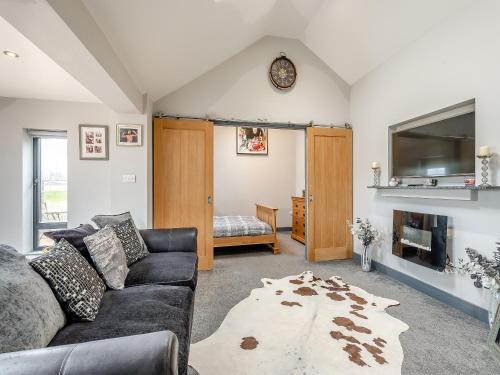 Una sala de estar con un sofá y una chimenea. en Mayton Lodge, en Fordwich
