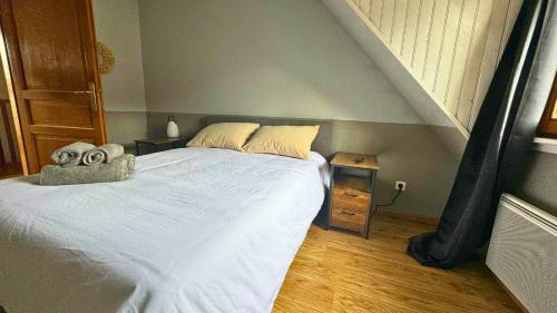 a bedroom with a white bed and a wooden floor at Le Rooftop du Schlossberg in Kaysersberg