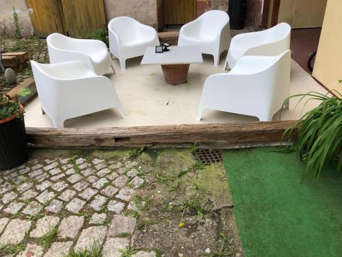 a group of white chairs sitting on a patio at Apartmány na Náměstí in Český Brod
