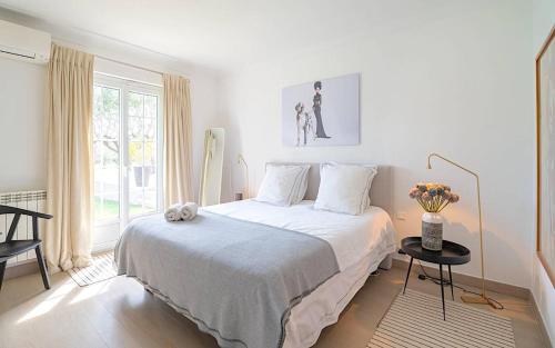 une chambre blanche avec un grand lit et une fenêtre dans l'établissement JAMES FCD56 - luxury villa with pool for rent in the vineyards near Saint Tropez, à Cogolin