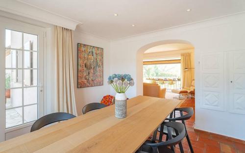 une salle à manger avec une table avec des chaises et un vase de fleurs dans l'établissement JAMES FCD56 - luxury villa with pool for rent in the vineyards near Saint Tropez, à Cogolin
