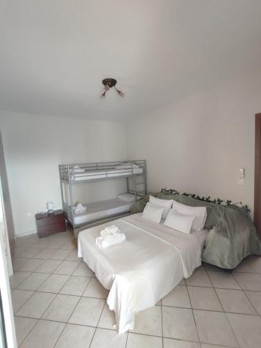 une chambre avec un grand lit avec des draps blancs dans l'établissement Anna Family Apartment, à Nikiti