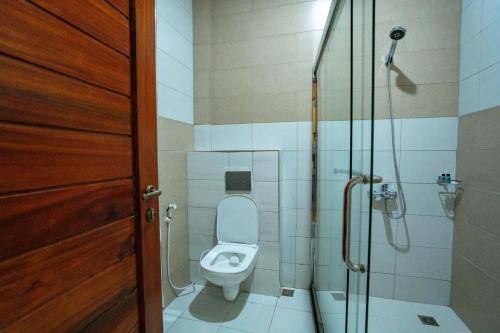 a bathroom with a toilet and a shower at La Mama Hotel in Uru