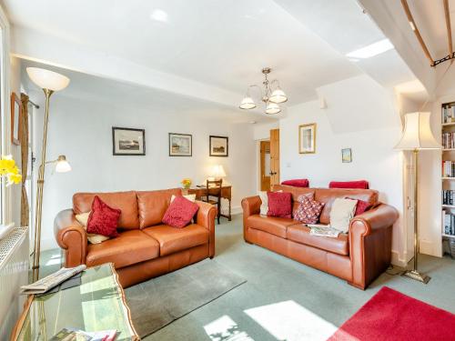 a living room with two brown leather couches at Hollow Creek Cottage - 28012 in Rockcliffe