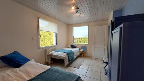 une chambre avec deux lits et une fenêtre dans l'établissement Gite de Kertanguy entre terre et mer, à Mespaul