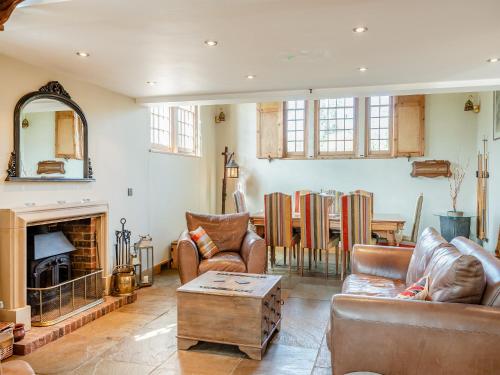 a living room with leather furniture and a fireplace at The Old Parish Hall in Quendon