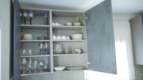 a cabinet filled with plates and bowls and dishes at Urban Nest in Alexandroupoli