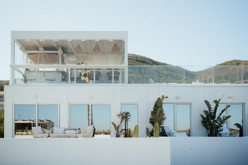 a white house with a lot of windows at We Surf House in Figueira da Foz