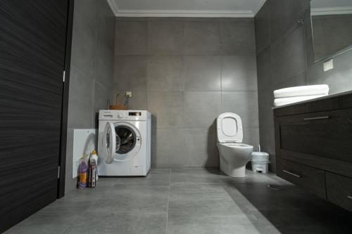 a bathroom with a washing machine and a toilet at Urban Nest in Alexandroupoli