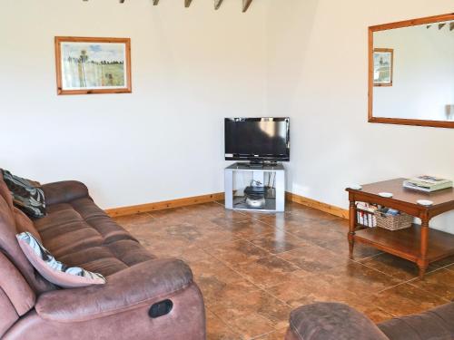 a living room with a couch and a tv at Meadow Cottage - Uk45882 in Flamborough