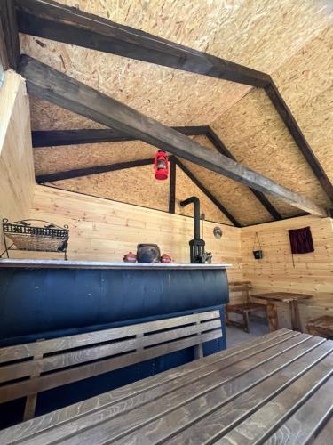 a room with a wooden ceiling with a wooden bench at Eko Katun Kolijevka in Berane