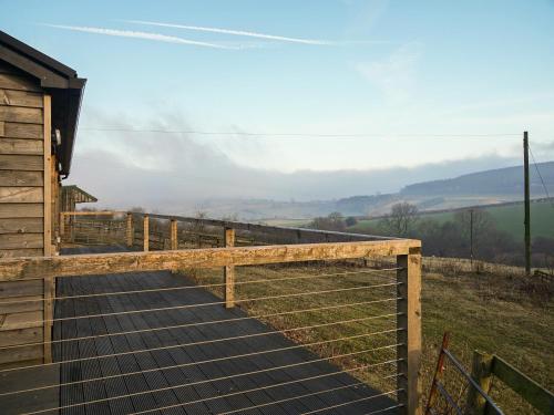 a wooden walkway leading to a building with a fence at The Old Stables in Presteigne
