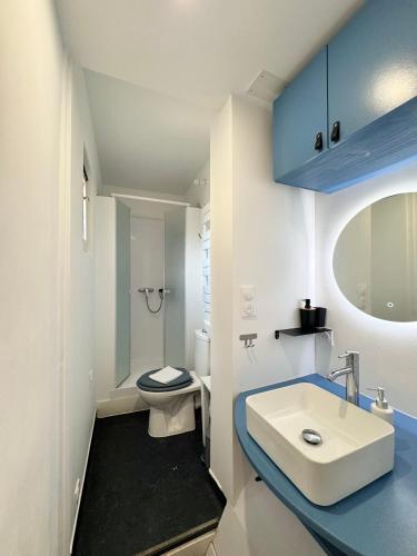 une salle de bain avec des toilettes blanches et un lavabo dans l'établissement Le Saint Melaine, Hyper centre de Rennes, à Rennes