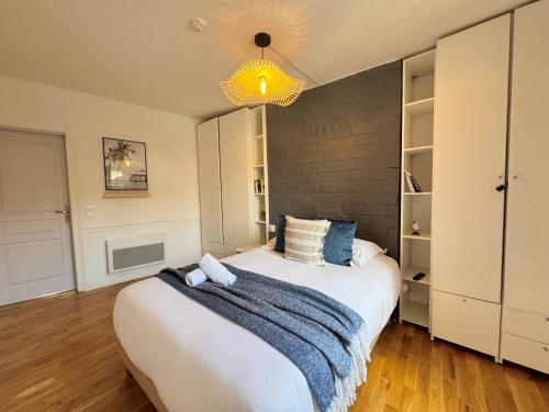 a bedroom with a bed with a blue blanket on it at Le Saint Melaine, Hyper centre de Rennes in Rennes