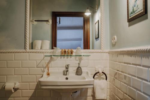a white bathroom with a sink and a mirror at Hotel Palacio de Caranceja in Reocín