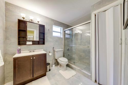 a bathroom with a shower and a toilet and a sink at 5 Mi to Surfside Beach Peaceful Miami Bungalow! in Miami