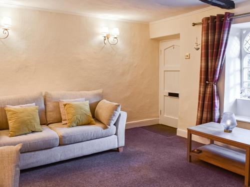 a living room with a couch and a table at Woodbine Cottage in Whittington