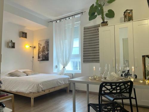 une chambre avec un lit, une table et un bureau dans l'établissement Marguerite6 cosy & tout équipé proche centre ville, à Reims