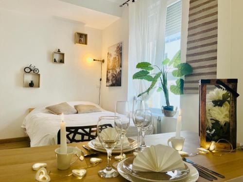 une salle à manger avec une table, des verres et des bougies dans l'établissement Marguerite6 cosy & tout équipé proche centre ville, à Reims