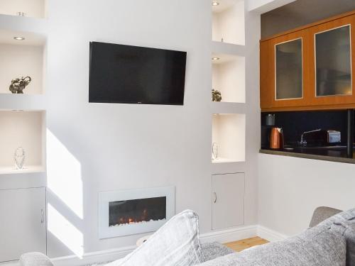 a living room with a fireplace and a flat screen tv at Church View in Cockermouth