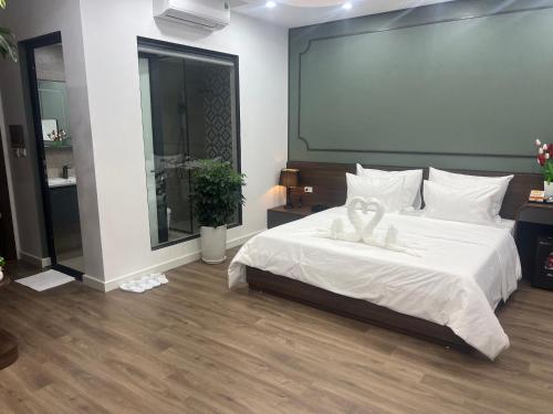 a bedroom with a white bed with a large screen at Ocean Park Homestay in HÆ°ng YÃªn