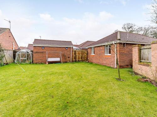 a backyard of a brick house with a lawn at 21 West Crayke in Sewerby